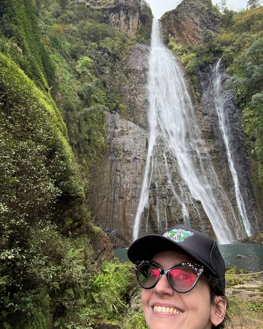 Sam smiling in front of Manawaiopuna Falls on Kaua'i
